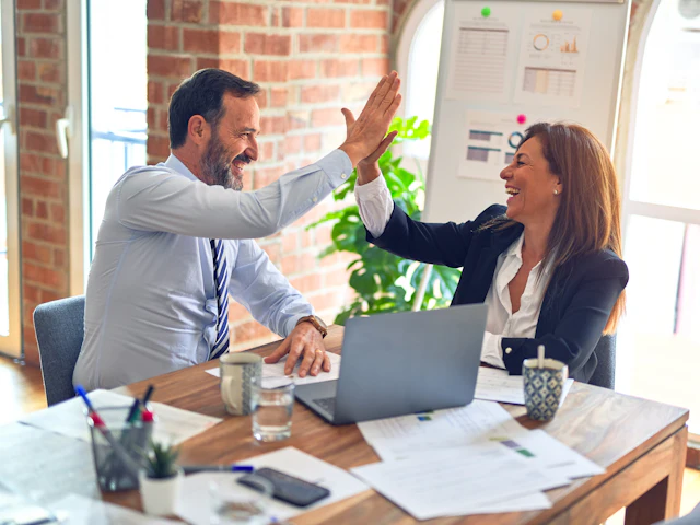 Two people talking through a project in a meeting room