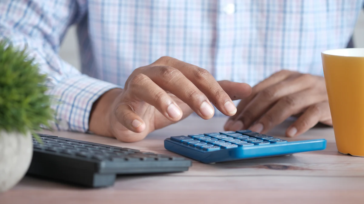 Person using a calculator at a desk with a coffee mug